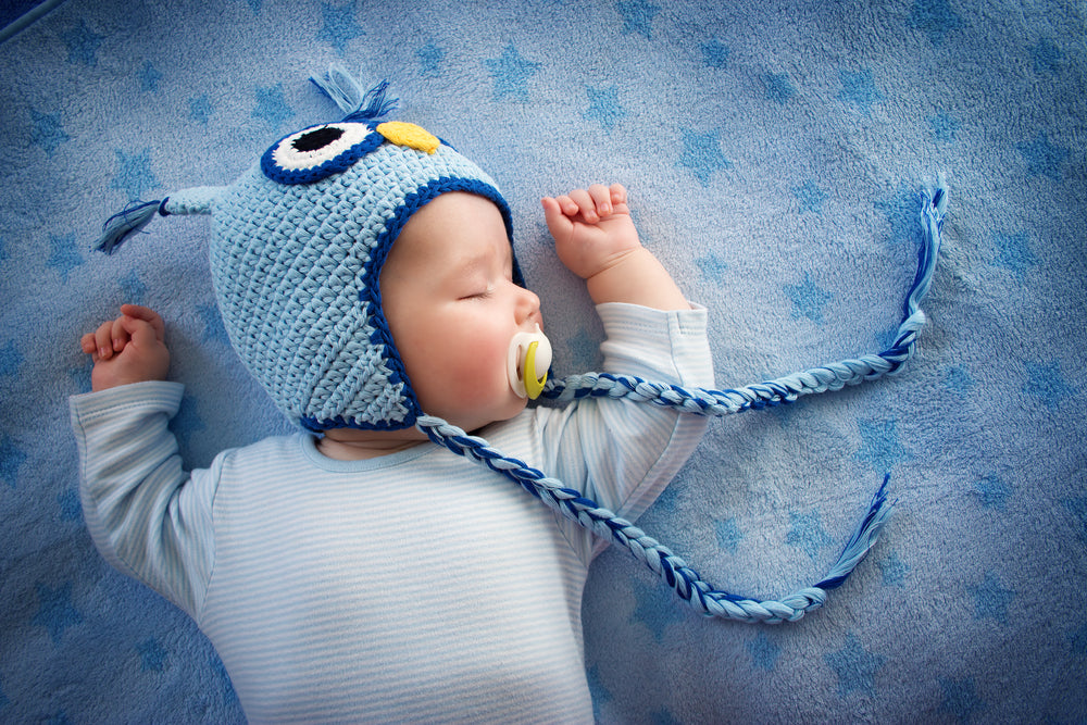 Baby sleeping on a blue blanket with stars